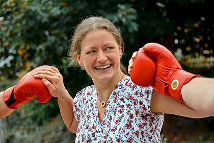 Photo: Social and Conflict Counseling Center 

(Photographer: Michael Deutsch)

[Image description: The photo shows Anke Mrker laughing as she stands between 
two fists that have red boxing gloves on them. She is wearing a patterned blouse 
and has brown hair tied in a braid].
